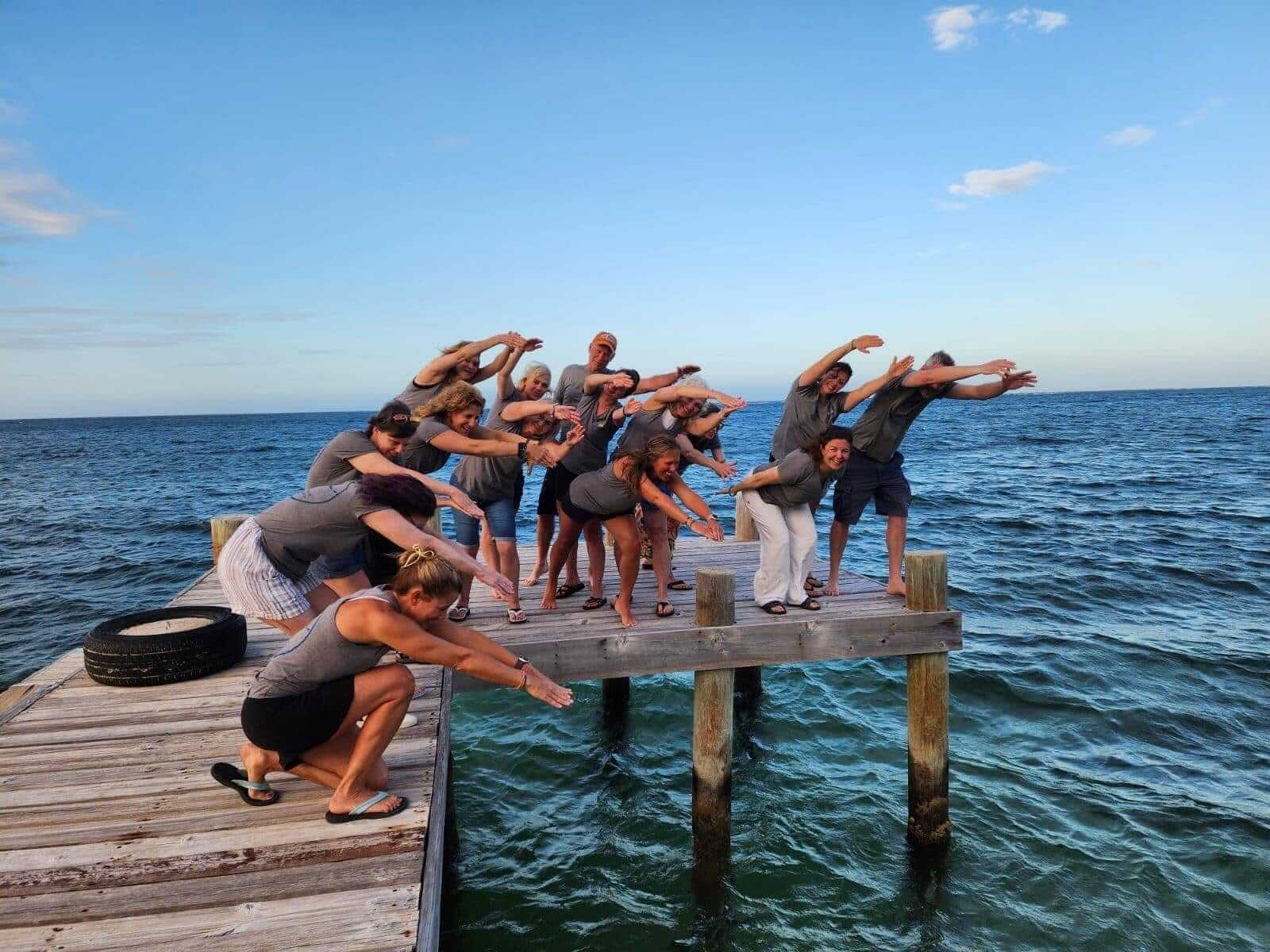The retreat group together on the dock at sunset, arms outstretched