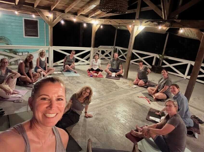 An evening dharma circle on the deck, lights strung overhead